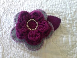 Grey and purple hand sewn felt and crocheted flower brooch.