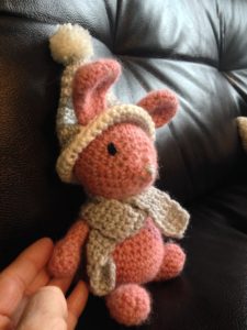 Little  pink alpaca wool crocheted bunny with grey and white winter hat and scarf.