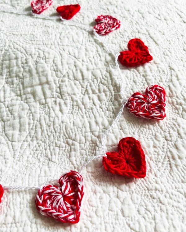 A garland of 11 red and white and solid red crocheted cotton hearts, on a white cotton chain. Approximately 110cm length. Each heart measures approximately 3.5cm width x 3cm height. This is a decoration only, and is NOT a toy. Keep out of the reach of babies and small children due to the small parts and risk of choking.