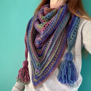 This large triangular wrap/shawl has been crocheted and is handmade. It has been crafted from a beautifully soft, supple and light-weight yarn in a rainbow of heather shades. The yarn is made of 100% Premium Acrylic which makes it extremely wearable and machine washable too. The label is made from 100% Polyurethane so is Vegan friendly. Approximate sizes of the wrap/shawl are: 153cm wide (not including tassels) x 72cm height. Each tassel is approximately 15cm long. This item is machine washable on a cool hand wash setting at 30c. Gently re-shape and dry flat. Do Not tumble dry. Do NOT iron.