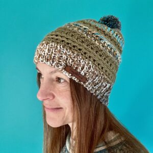 A soft and chunky textured hat with a large detachable bobble. Made in a khaki green yarn and a complimentary mix of cream, brown, grey and turquoise. Both yarns are very soft and chunky, yet lightweight and warm. The yarn is made of 100% Acrylic which makes it extremely wearable and machine washable too. The label is made from 100% Polyurethane so is Vegan friendly. This item is machine washable on a warm hand wash setting at 40c. Gently re-shape and dry flat. Do Not tumble dry. Do NOT iron.