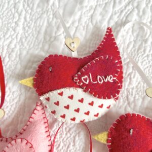 A hand cut and hand stitched, felt and fabric bird, with a cream ribbon hanging loop and wooden heart button detail. The word love is hand embroidered on the wing. Robins approximate size 8cm w x 5cm h. (excluding hanging ribbon.) This is a decoration only, and is NOT a toy. Keep out of the reach of babies and small children due to the small parts.