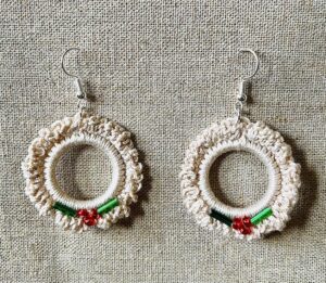 Hand made, crocheted, mini wreath earrings. Made using 100% cotton in natural cream colour with a mix of red and green glass beaded details. The earring hooks are made from a silver plated brass and are nickel, lead and cadmium free. Each earring measures approximately 3.5cm wide by 5.5cm Height (including hook).