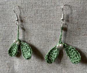 Hand made, crocheted, mini mistletoe earrings. Made using 100% cotton in soft green colour with glass pearl effect beaded details. The earring hooks are made from a silver plated brass and are nickel, lead and cadmium free. Each earring measures approximately 3cm wide by 5cm Height (including hook).