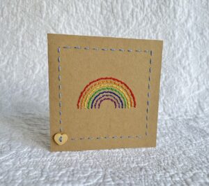 A hand stitched rainbow greetings card with wooden heart button detail. 

A blank, white paper insert is included for you to write your own message. Envelope included.

Approximate size 10cmX 10cm.

Made using 100% Cotton. Eco-friendly, Vegan friendly and fully recyclable. 