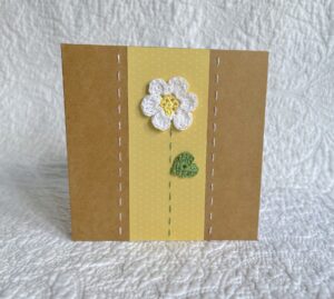 A single crocheted flower and leaf, with a hand stitched border. 

This small brown card has a blank white insert for your own message, and an envelope is included.

Approximate size 10cm x 10 cm.

Made using 100% cotton.
Eco-friendly, Vegan friendly and fully recyclable.