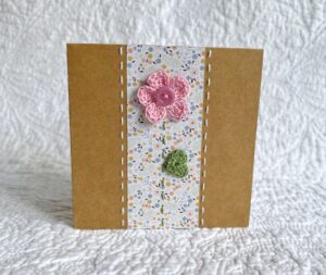 A single crocheted flower and leaf, with a hand stitched border. 

This small brown card has a blank white insert for your own message, and an envelope is included.

Approximate size 10cm x 10 cm.

Made using 100% cotton.
Eco-friendly, Vegan friendly and fully recyclable.