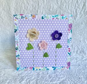 A trio of crocheted flowers and leaves, with buttons and hand stitched details. This spotty card has a blank white insert for your own message, and an envelope is included. Approximate size 15cm x 15 cm. Made using 100% cotton. Eco-friendly, Vegan friendly and fully recyclable.