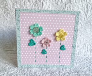 A trio of crocheted flowers and leaves, with buttons and hand stitched details. This spotty card has a blank white insert for your own message, and an envelope is included. Approximate size 15cm x 15 cm. Made using 100% cotton. Eco-friendly, Vegan friendly and fully recyclable.