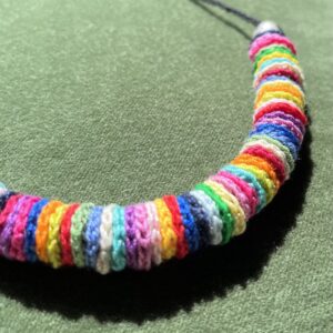 A handmade, crocheted necklace of multicoloured discs, made using 100% cotton and metal beads/fixings. No plastic has been used. This item is Vegan and Eco-friendly, reusable and fully recyclable.