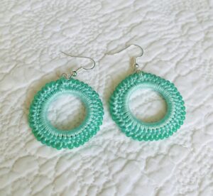 A handmade, crocheted pair of beaded hoop earrings, made using 100% cotton, glass beads and metal fixings. The earring hooks are made from a silver plated brass and are nickel, lead and cadmium free. Each earring measures approximately 3.4cm wide by 5cm Height (including hook). No plastic has been used. This item is Vegan and Eco-friendly, reusable and fully recyclable.