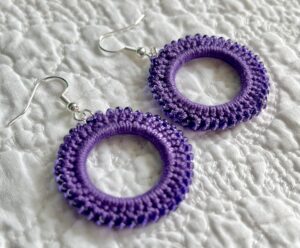 A handmade, crocheted pair of beaded hoop earrings, made using 100% cotton, glass beads and metal fixings. The earring hooks are made from a silver plated brass and are nickel, lead and cadmium free. Each earring measures approximately 3.4cm wide by 5cm Height (including hook). No plastic has been used. This item is Vegan and Eco-friendly, reusable and fully recyclable.