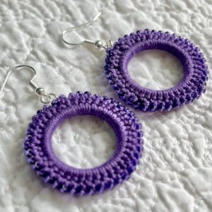 A handmade, crocheted pair of beaded hoop earrings, made using 100% cotton, glass beads and metal fixings. The earring hooks are made from a silver plated brass and are nickel, lead and cadmium free. Each earring measures approximately 3.4cm wide by 5cm Height (including hook). No plastic has been used. This item is Vegan and Eco-friendly, reusable and fully recyclable.