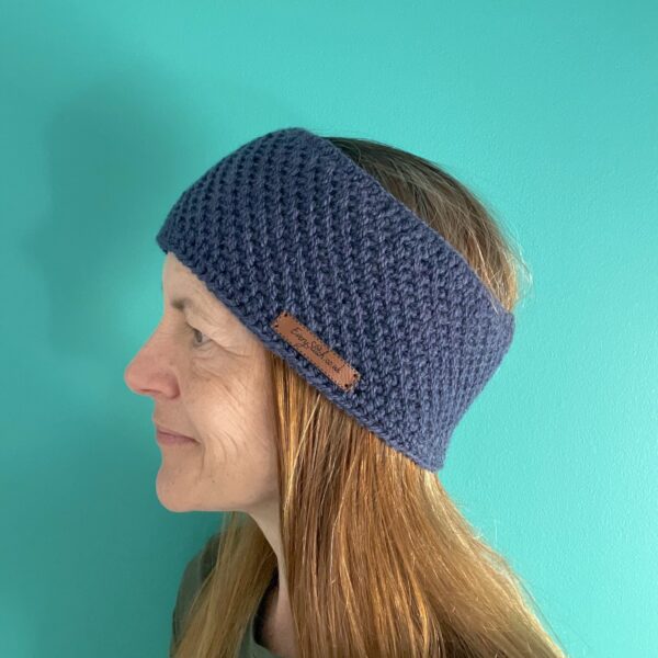 A handmade, close textured, crocheted ear warmer , made using a soft 75% acrylic and 25% wool mix yarn in blue with a subtle touch of purple.