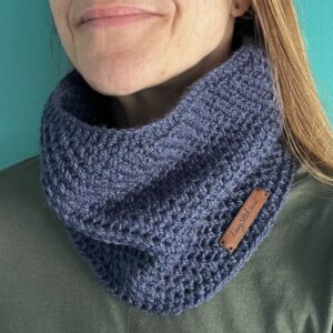 A handmade, close textured, crocheted neck warmer, made using a soft 75% acrylic and 25% wool mix yarn in blue with a subtle touch of purple.