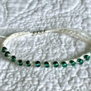 A handmade, crocheted, fully adjustable, single stranded bracelet. Made using glass and metal beads and 100% cotton. No plastic!